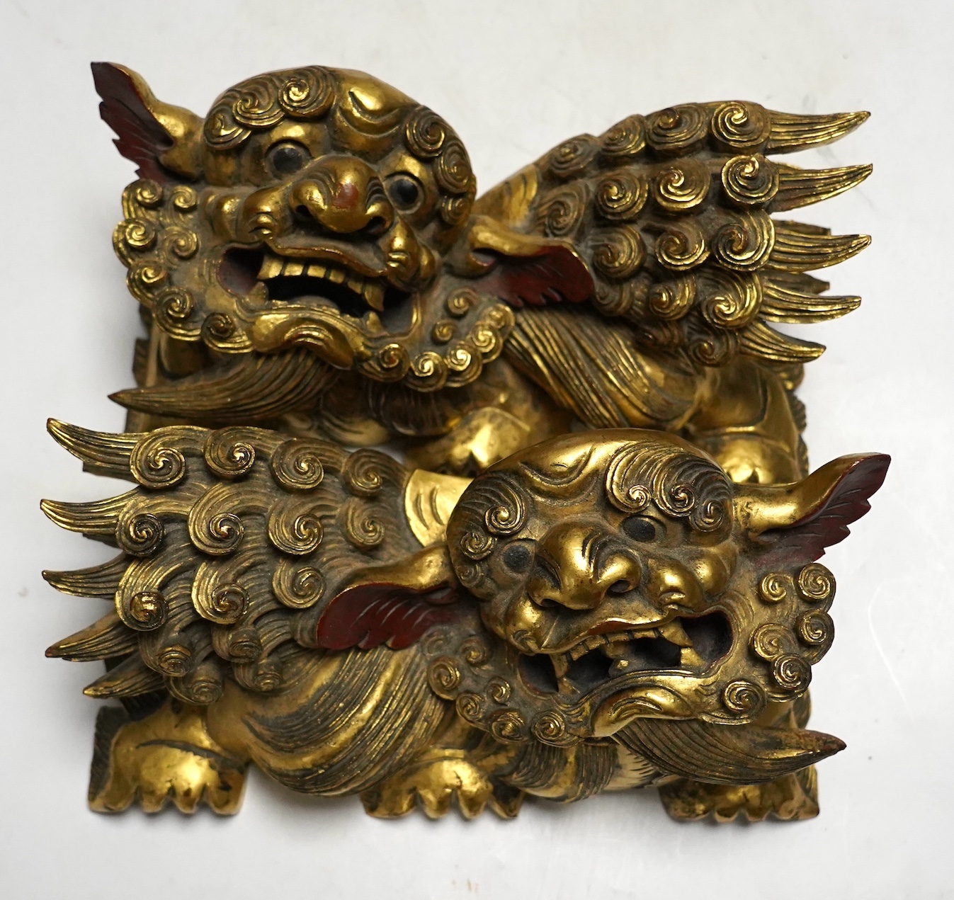 A pair of 20th century Chinese carved giltwood lion mounts, 23cm wide